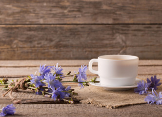 Obraz na płótnie Canvas Cup of tea with chicory on wooden background