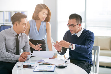 Asian businessman talking to coworkers about his project