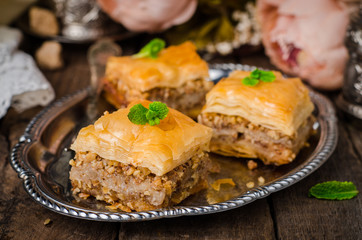 Walnuts baklava in oriental tray on wooden background. East sweets. Ramadan food. Selective focus