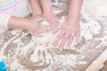Family hands together working on dough