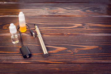 electronic nicotine inhalator on  background ,bottles with liquids behind the inhalator.