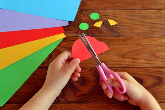 Child cuts a car out of paper. Sheets of colored paper. Kids art. Kids crafts. Crafts concept. How to make a greeting card father's day