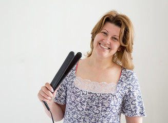 positive woman with curling tongs