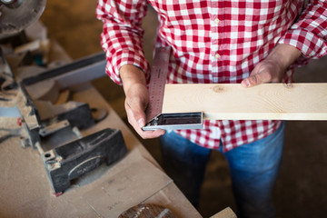 Carpenter measures the board thickness of the corner, joiner's s
