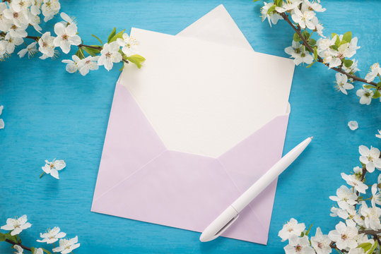 Flowers, envelope and pen on wooden background 