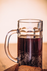 Russian brew in mug  and loaf of rye flour on wooden background