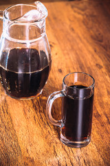 Russian brew in mug and jug of rye flour on wooden background