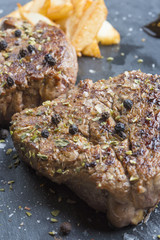 Grilled T-bone steak seasoned with spices and fresh herbs served