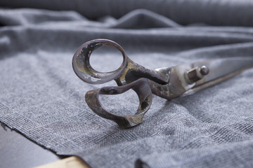 25 September 2012 at a tailor in Barcelona, Spain. Production process of suit tailoring. Still life of a tailoring scissors on woolen fabric.