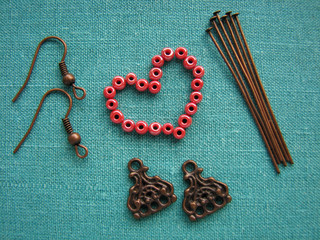 Red beads in form of heart, making earrings, handmade jewelry