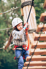 Active little boy on the rope park attraction