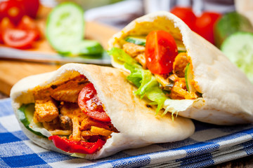 Fried chicken meat with vegetables in pita bread