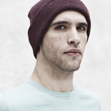 Portrait of man wearing knit hat against white background