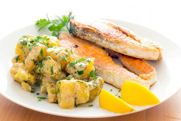 Salmon steak dinner with herbs and roasted potatoes