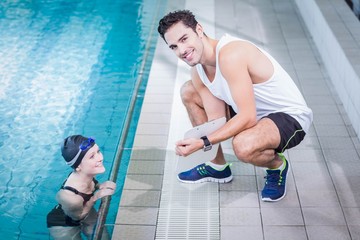 Fit trainer talking to swimmer