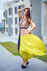 Beautiful brunette in a dress on the street.