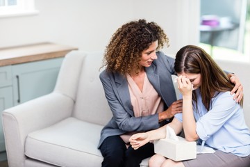 Psychologist consoling depressed woman at home