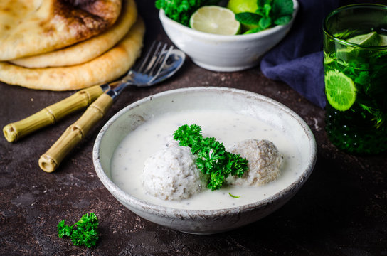 Kibbeh bil laban - arabian yogurt soup with stuffed bulgur cutletson dark background. Selective focus