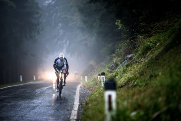 Man cycling on a wet road in rain, Salzburg, Austria