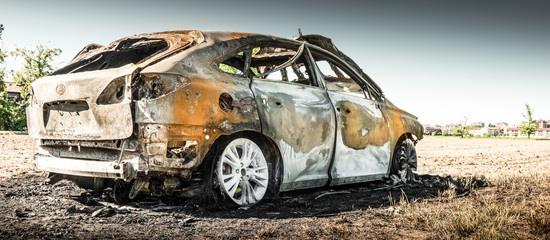 automobile carbonizzata in un campo