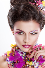 Fototapeta premium Fashion Beauty woman with flowers in her hair and around her neck. Perfect Creative Make up and Hair Style. Hairstyle. Bouquet of Beautiful Flowers. It can be used for advertising perfume