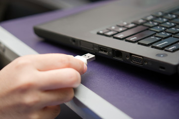 Obraz na płótnie Canvas Virus USB thumb drive plug in to laptop computer port