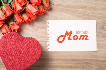 Mother's day card. Bouquet of red roses on wooden background.