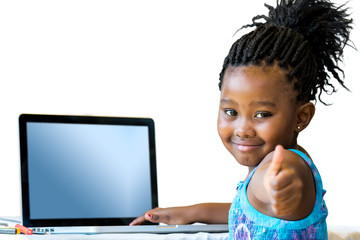 Little african girl doing thumbs up at desk.
