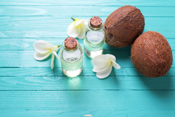 Bottles with coconut oil on  bright  wooden background.