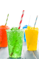 Colorful summer slushies on blue wood
