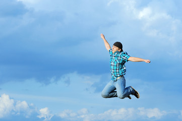 Boy jumping, running against blue sky