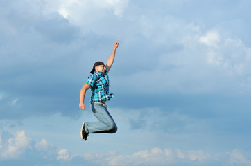 Fototapeta premium Boy jumping, running against blue sky