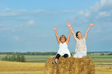 Fototapeta na wymiar Two girls enjoying the nature in the hay