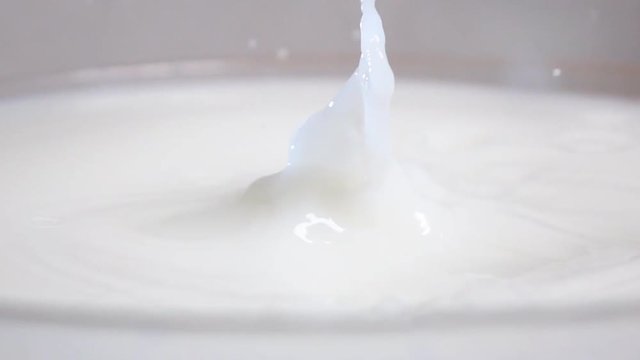 Fresh tasty yellow apple dropping into the white liquid milk in high slow motion. Shot on high-speed camera sony rx 10 ii in 500 fps mode