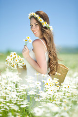 Beautiful woman on the camomile field 