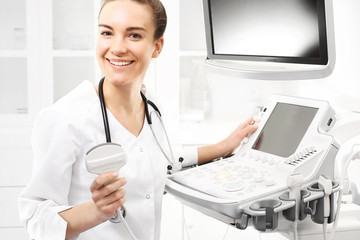 Uśmiechnięta lekarka, badanie ultrasonograficzne. Lekarz przeprowadza badanie ultrasonograficzne.