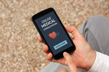 Hands holding smart phone with online medical consultation concept on screen. All screen content is designed by me