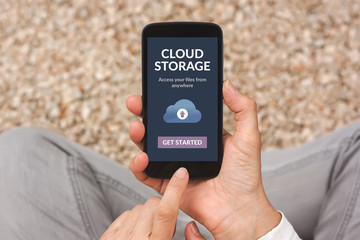 Hands holding smart phone with cloud storage app concept on screen. All screen content is designed by me