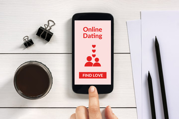 Online dating concept on smart phone screen with office objects on white wooden table. All screen content is designed by me.