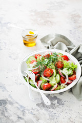 Fresh salad with cherry tomatoes, cucumbers, radishes, dill and olive oil, selective focus