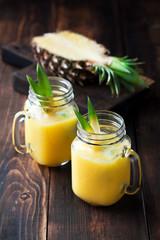 Healthy pineapple smoothie in mason jars, selective focus