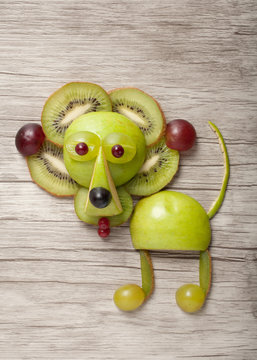 Funny lion made of fresh fruits on wood