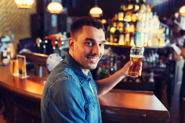 happy man drinking beer at bar or pub