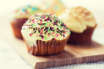close up of glazed cupcakes or muffins on table