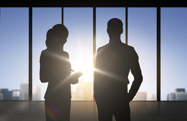 silhouettes of business partners over office