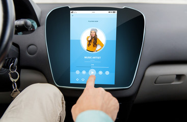 close up of male hand using music player in car