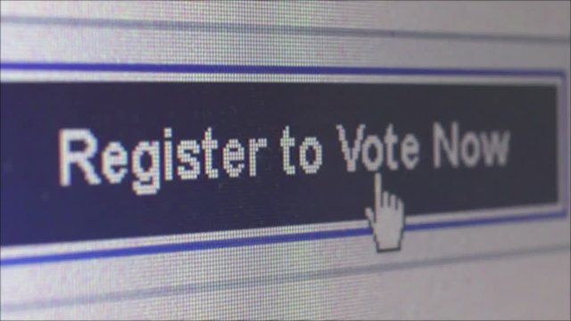 Macro close up of user moving cursor and clicking on a long blue banner which says 'Register to Vote.' Camera then dollies right; shot at pixel level with special lenses. (*not a screengrab)