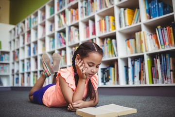 Girl lying and reading a book