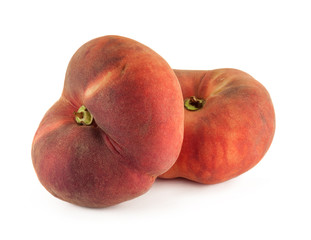 Two flat donut peaches isolated on a white background