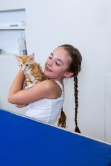 A little girl bringing a kitten